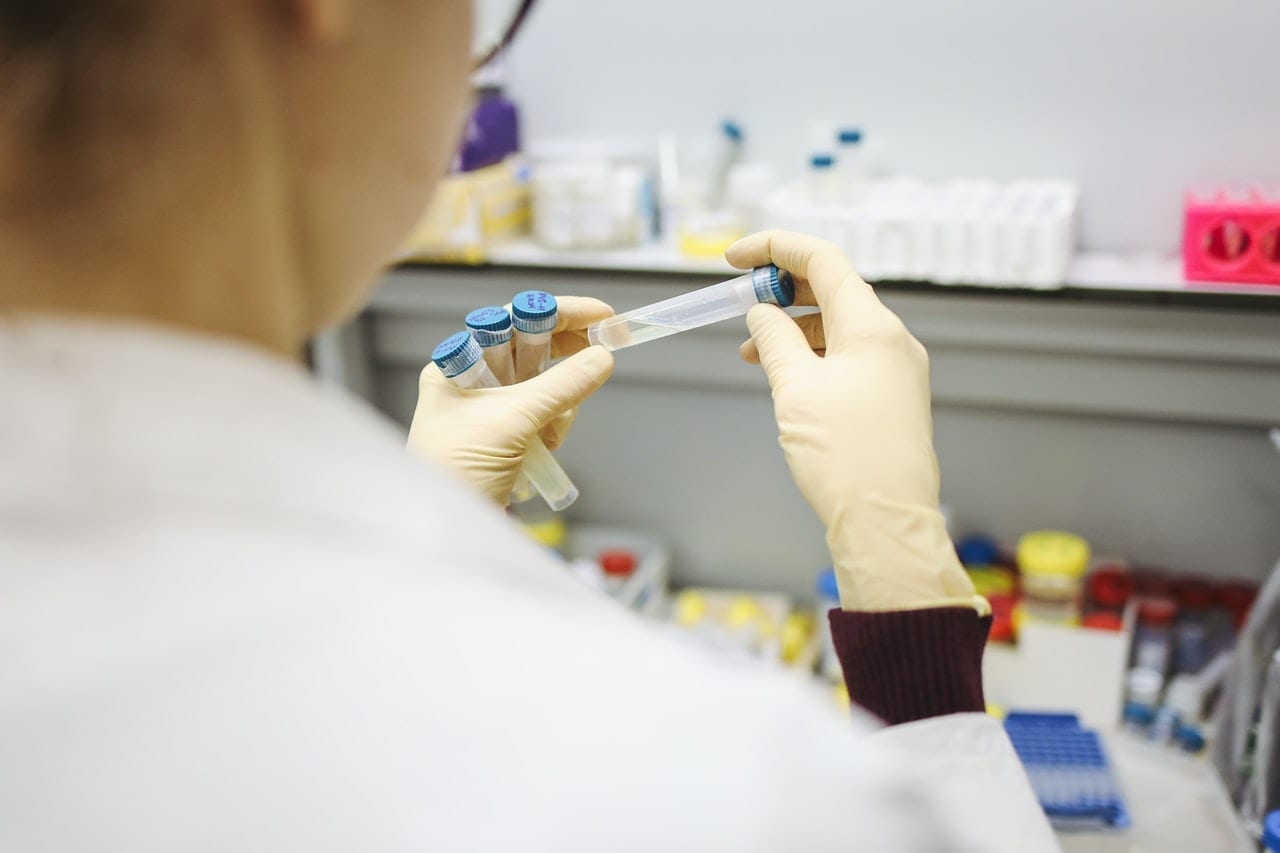 back view of a lab technician holding test tubes