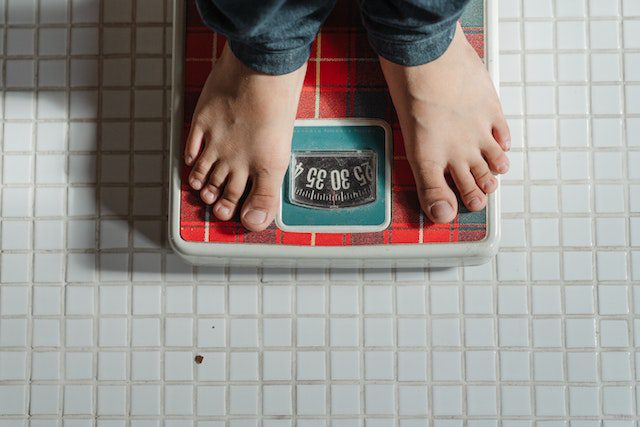 A person weighing on a scale: How to wean off thyroid medication